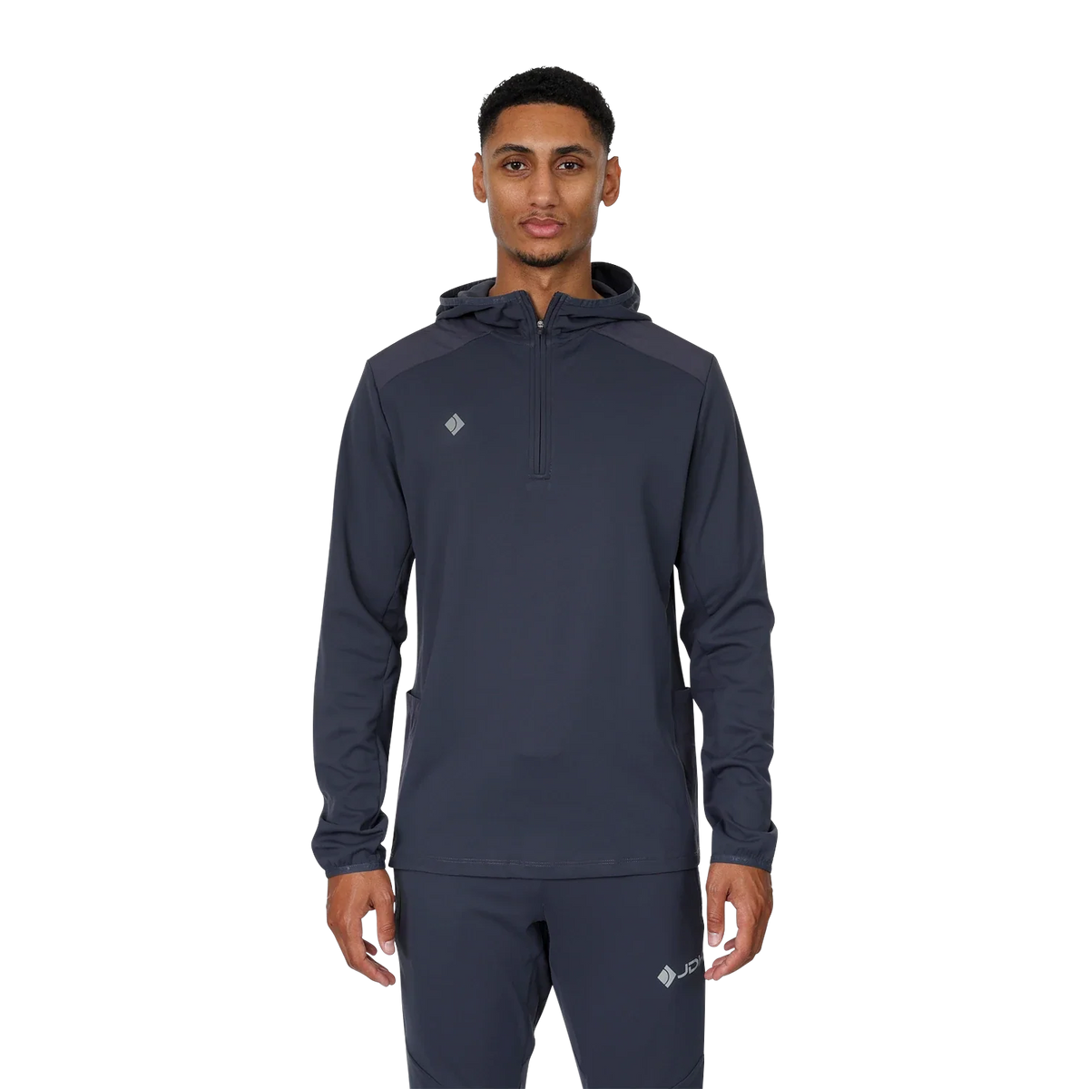 Model draagt de complete JDH Midlayer Ink set: antracietgrijze midlayer met capuchon en bijpassende trainingsbroek