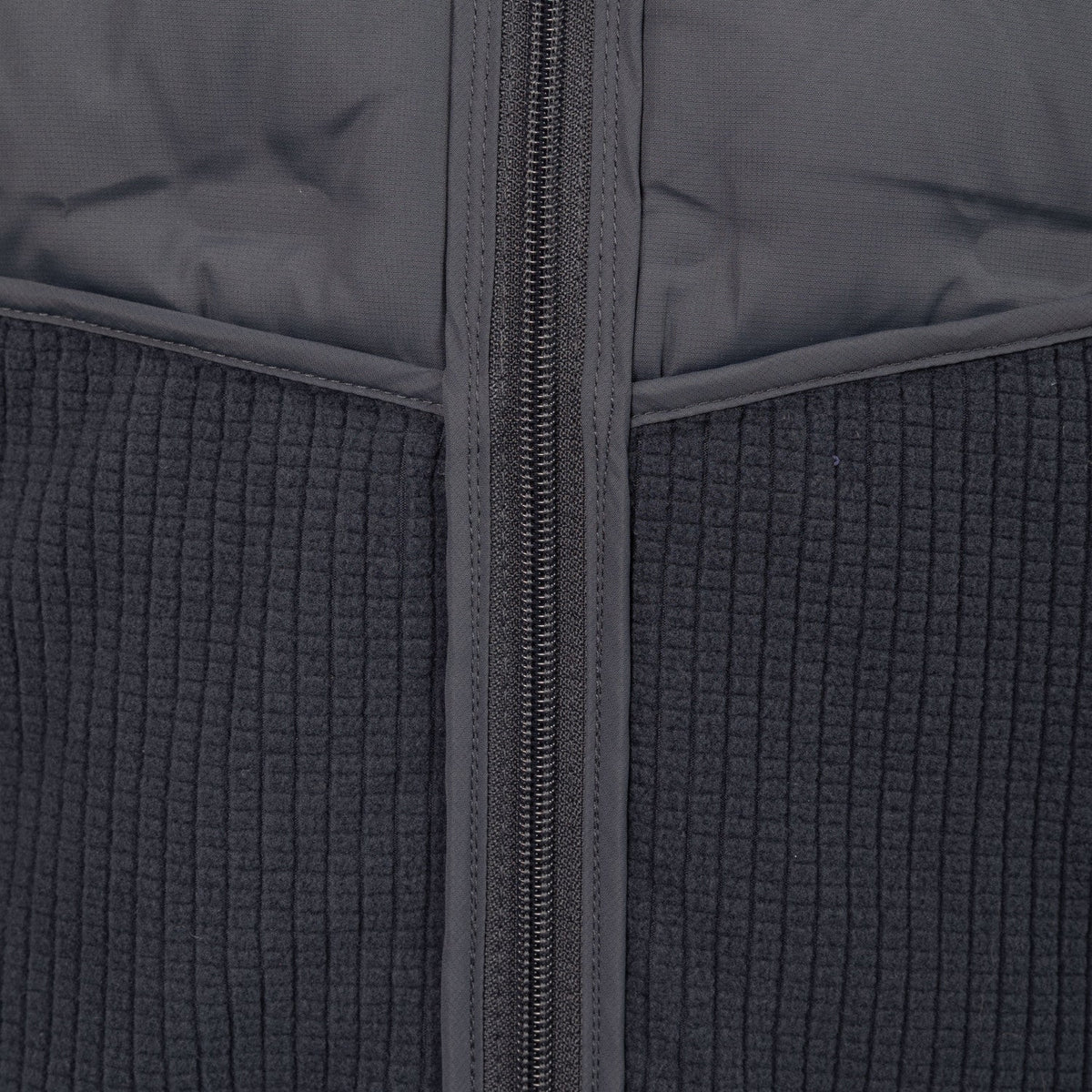 Detail van de rits en de gewatteerde stof van het donkergrijze Hybrid Padded jack