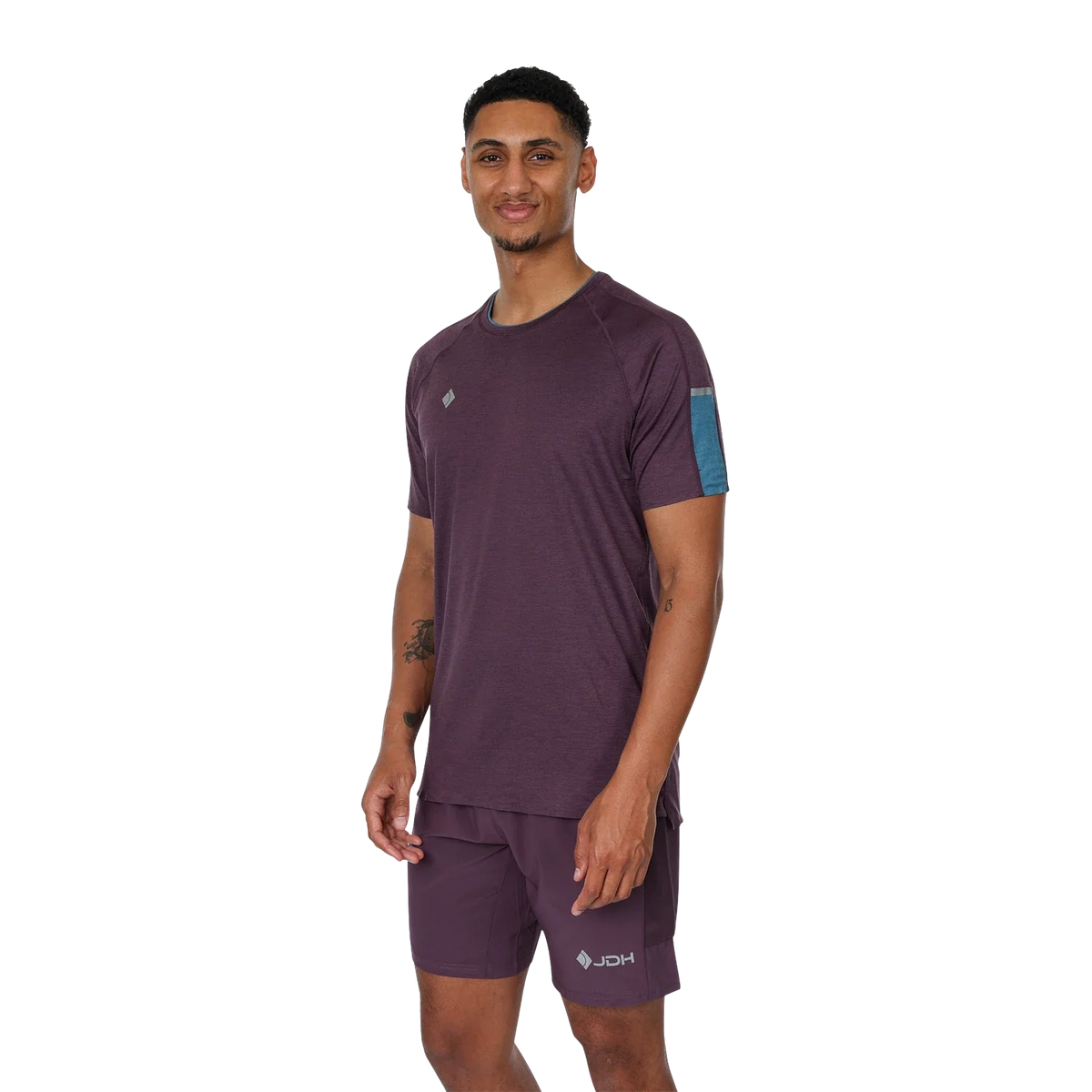 Model draagt de complete JDH Performance Plum set: aubergine shirt met bijpassende short