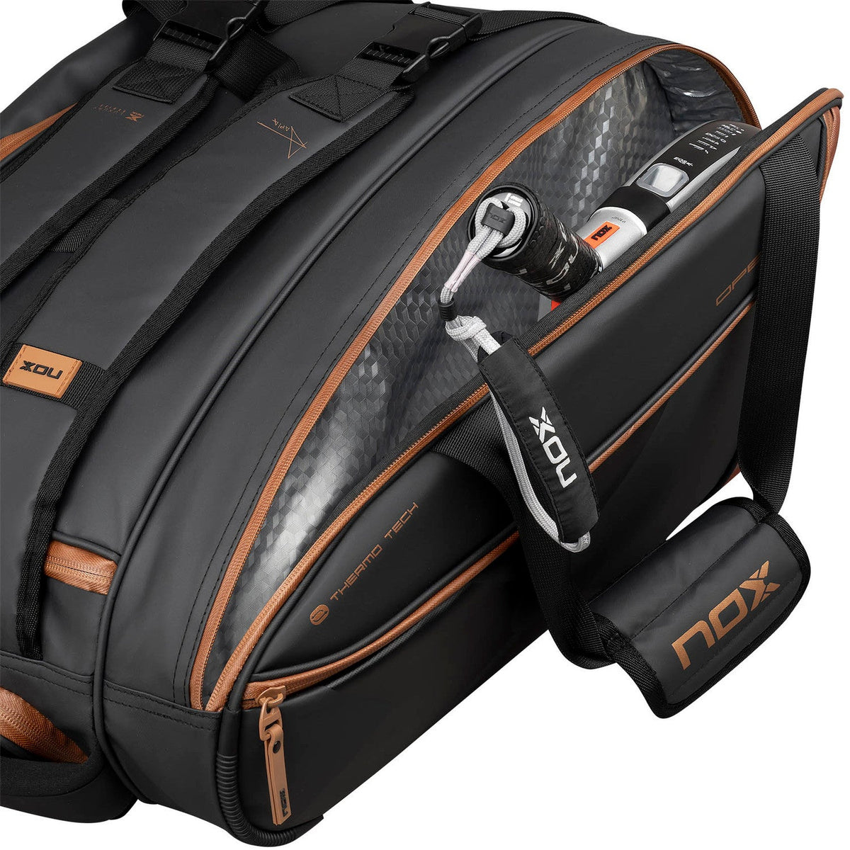 Geopende zwart-bruine Nox Luxury racketbag met accessoires in het geopende zijvak