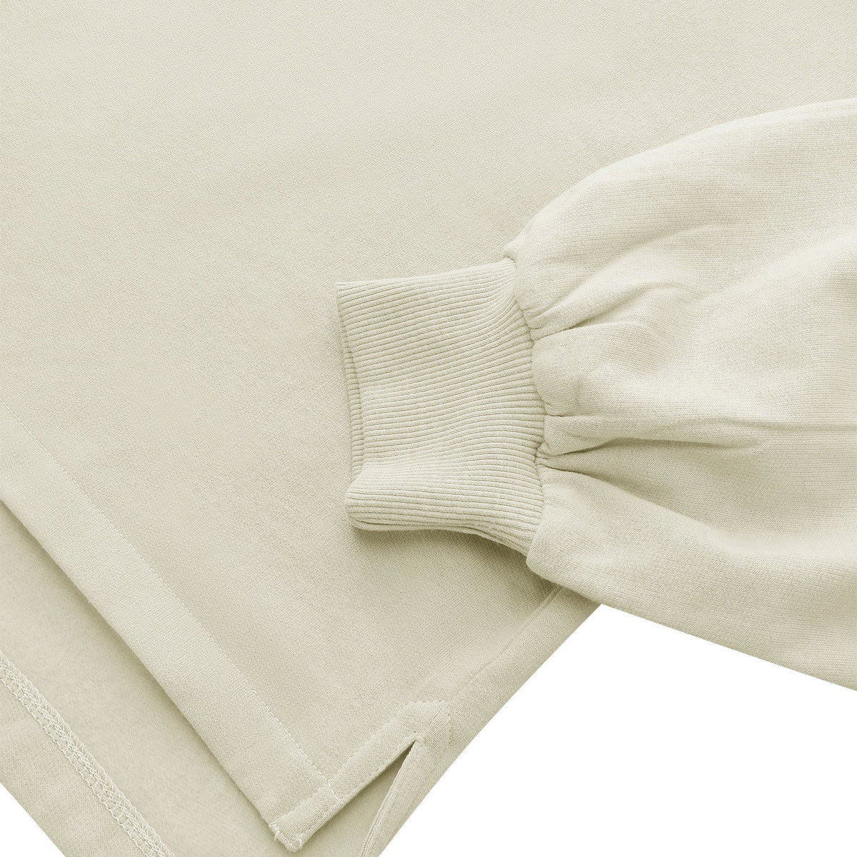 Detail van de onderzoom met split en manchet van de zandkleurige Osaka Half Zip Sweater