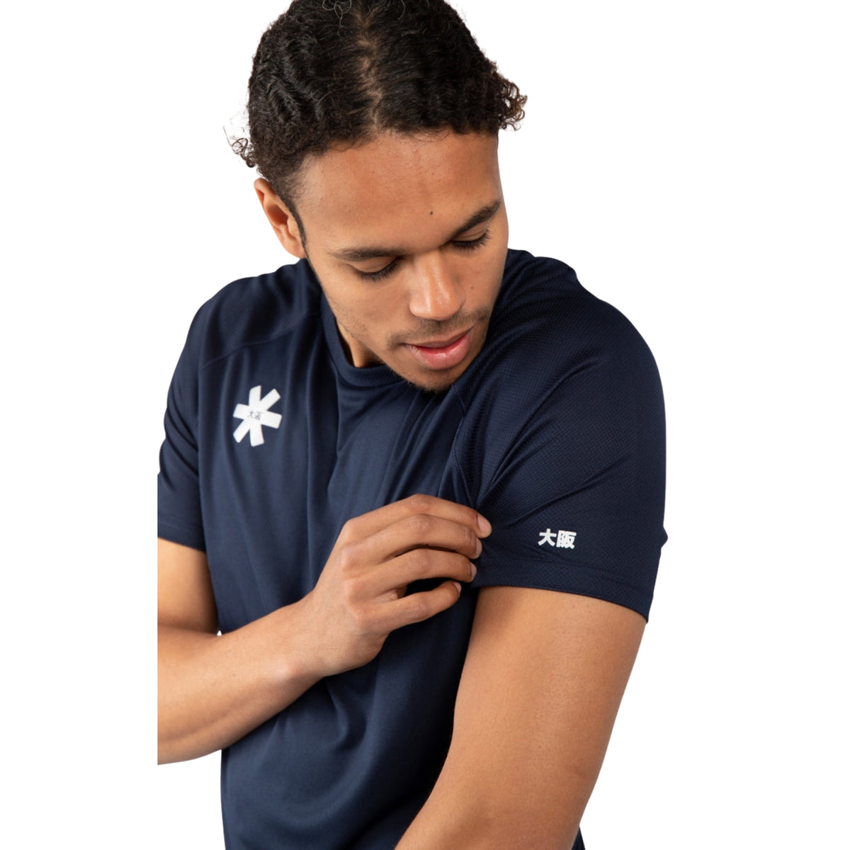 Model toont het Osaka-logo op de mouw van het donkerblauwe Training T-shirt