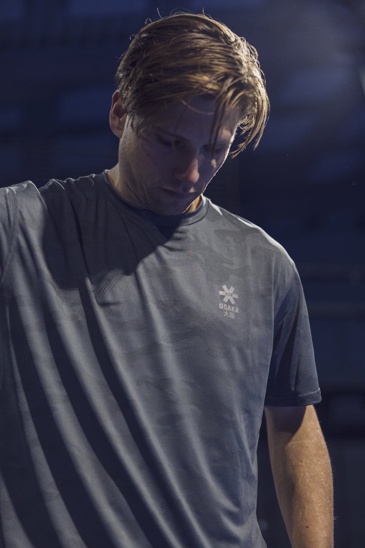 Sfeerfoto van een speler in het Osaka T-Shirt Training in gedempt blauwgrijs licht