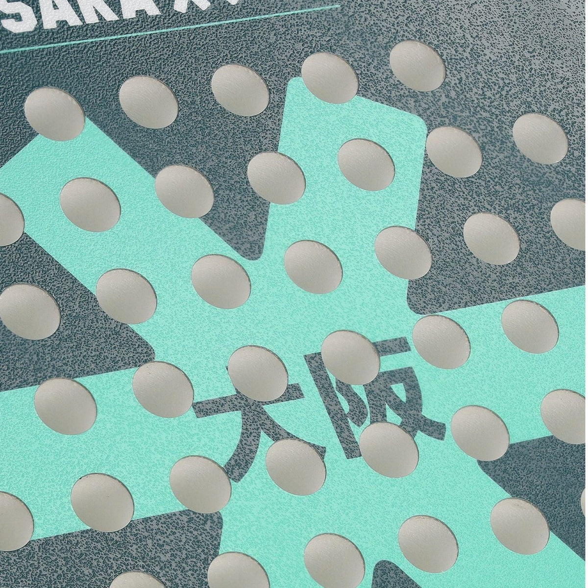 Macro-opname van het slagvlak van de Osaka Vision Power Teal met mintgroene ster