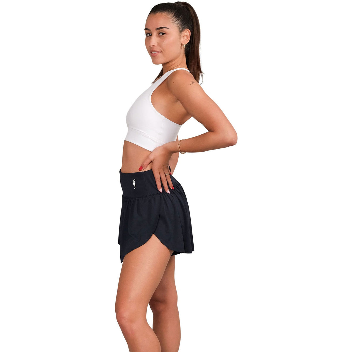 Zijaanzicht van een model in de donkerblauwe RS Women Court Pleated Shorts met logo