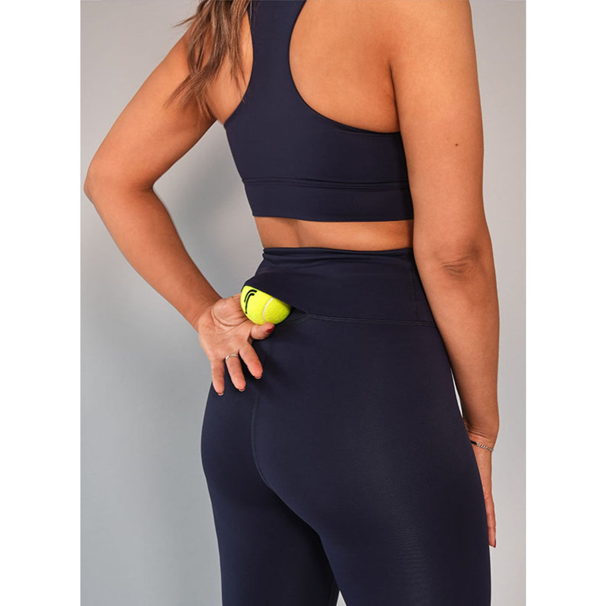 Detail van de achterzak met padelbal op de donkerblauwe RS Stretch Tech legging