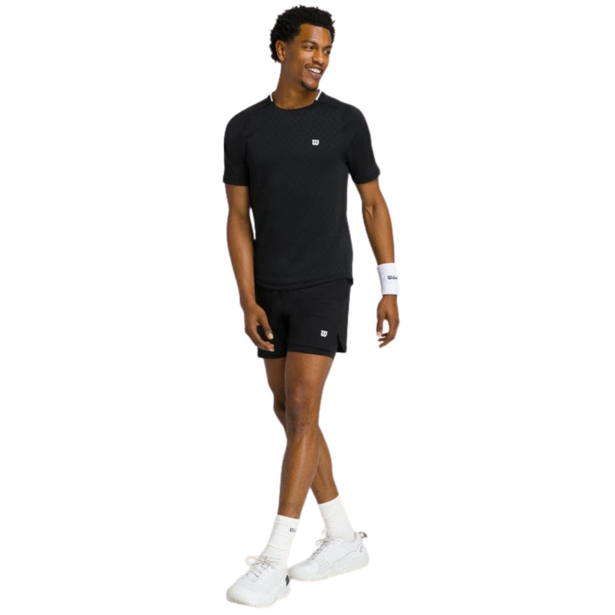 Model ten voeten uit in het zwarte Wilson Serve Out T-shirt met zwarte short