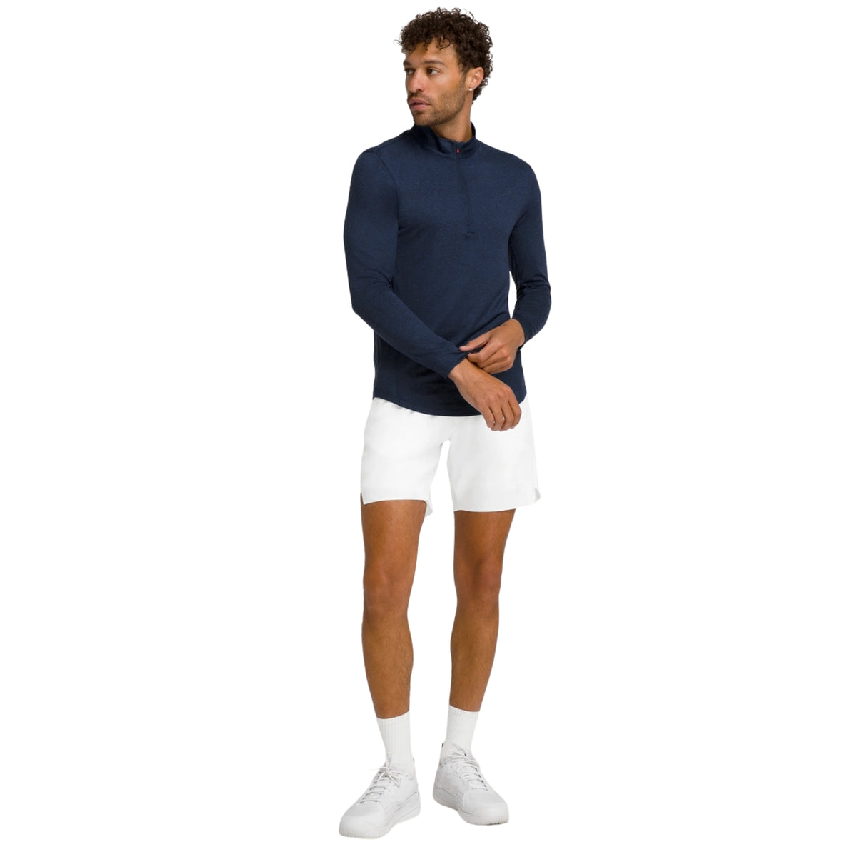 Model ten voeten uit in de witte Wilson Tournament short en blauwe longsleeve