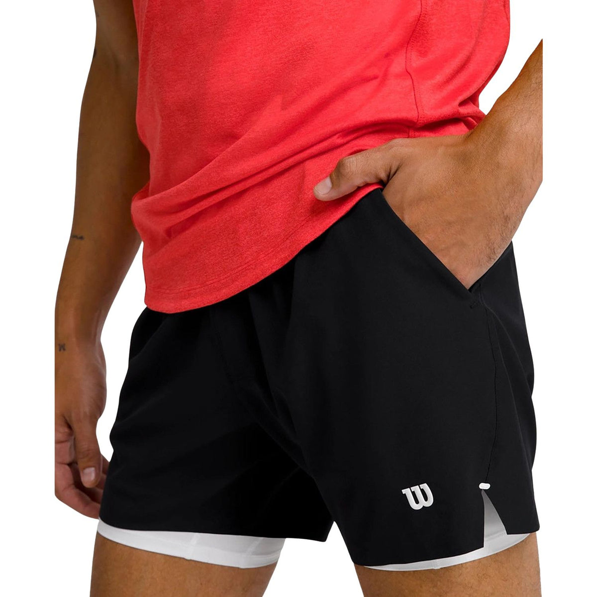 Close-up van de zwarte Wilson Tournament short met hand in de steekzak
