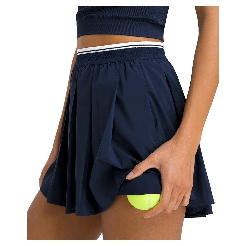 Padelbal in de zak van de donkerblauwe Wilson Velocity plisseshort