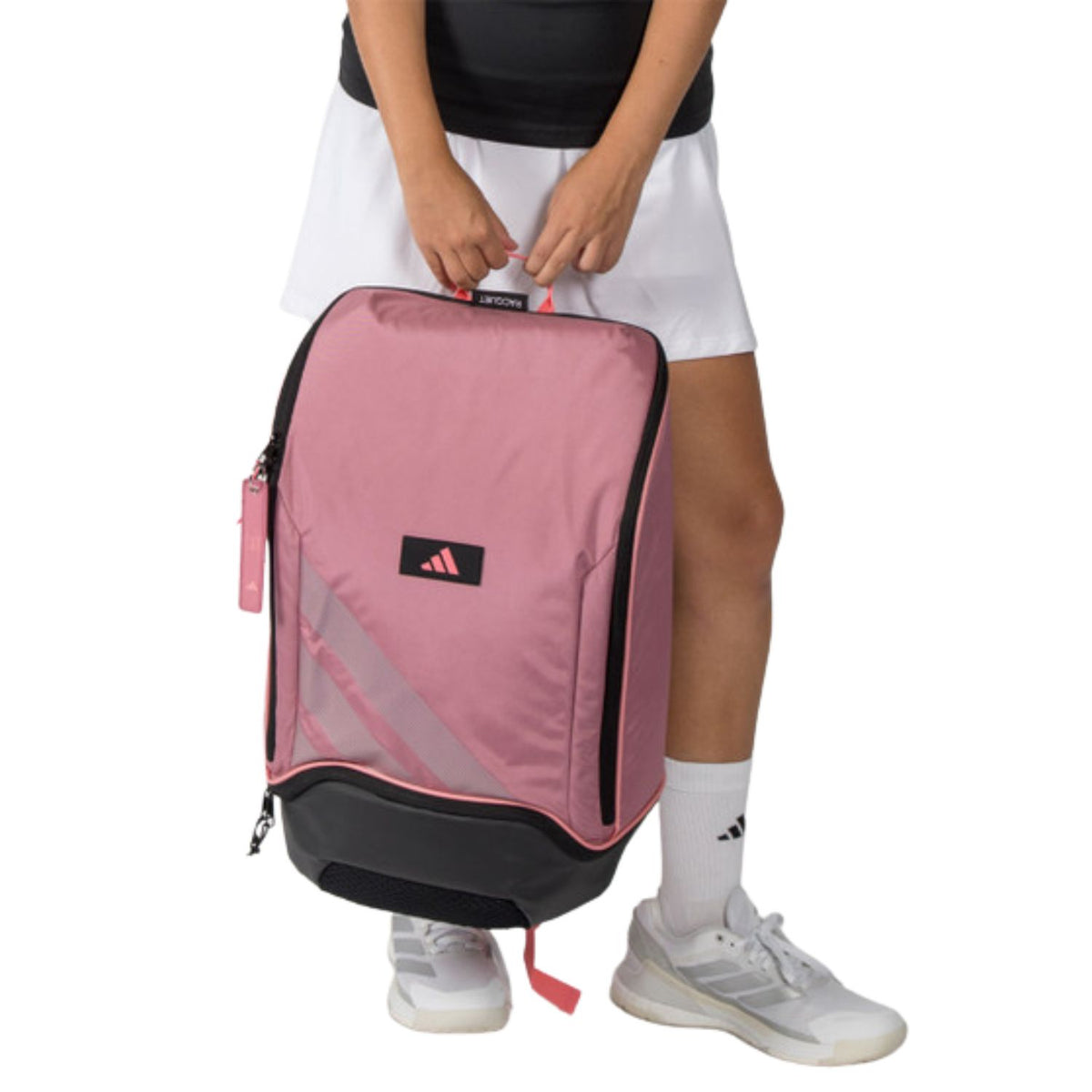 Model houdt de roze Adidas Backpack Protour 2026 aan de handgreep vast.