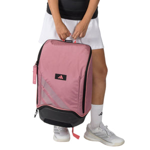 Model houdt de roze Adidas Backpack Protour 2026 aan de handgreep vast.