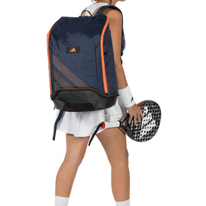 Speelster van achteren met de marineblauwe Adidas Protour 2026 rugzak en racket in de hand.