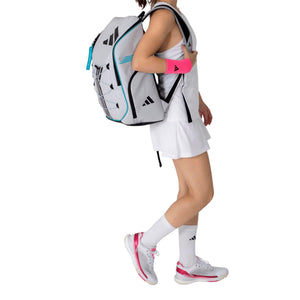 Model draagt de witte Adidas Backpack Protour 3.4 over een schouder in tenniskleding.