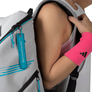 Detail van de schouderband van de witte Adidas Protour 3.4 met turquoise hanglabel.