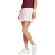Model draagt de lichtroze Adidas Classics rok met bordeauxrode polo, vooraanzicht