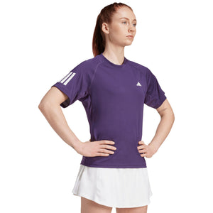 Model met handen in de zij draagt het paarse Adidas Club T-shirt en witte rok