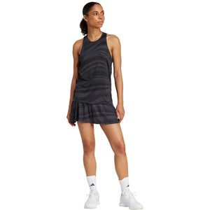 Model in volledige outfit met de donkergrijze Adidas Club Graphic Tank en plooirok
