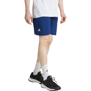 Vooraanzicht van model in de donkerblauwe Adidas Club Stretch short met wit logo
