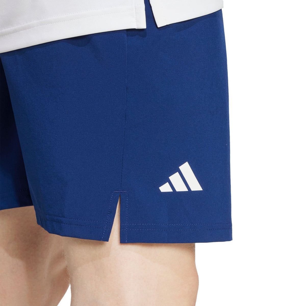 Detail van de pijp van de donkerblauwe Club Stretch short met wit Adidas-logo en split
