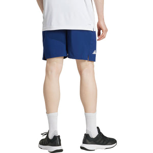 Achteraanzicht van model in de donkerblauwe Adidas Club Stretch short met wit logo