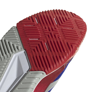 Close-up van het rode zoolprofiel van de blauwe Adidas Courtquick