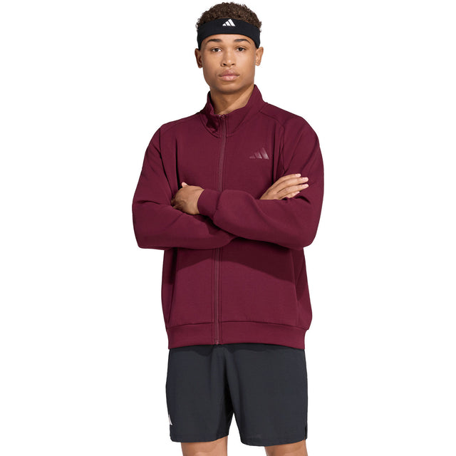 Model draagt het Adidas Cover Up trainingsjack voor heren in bordeaux