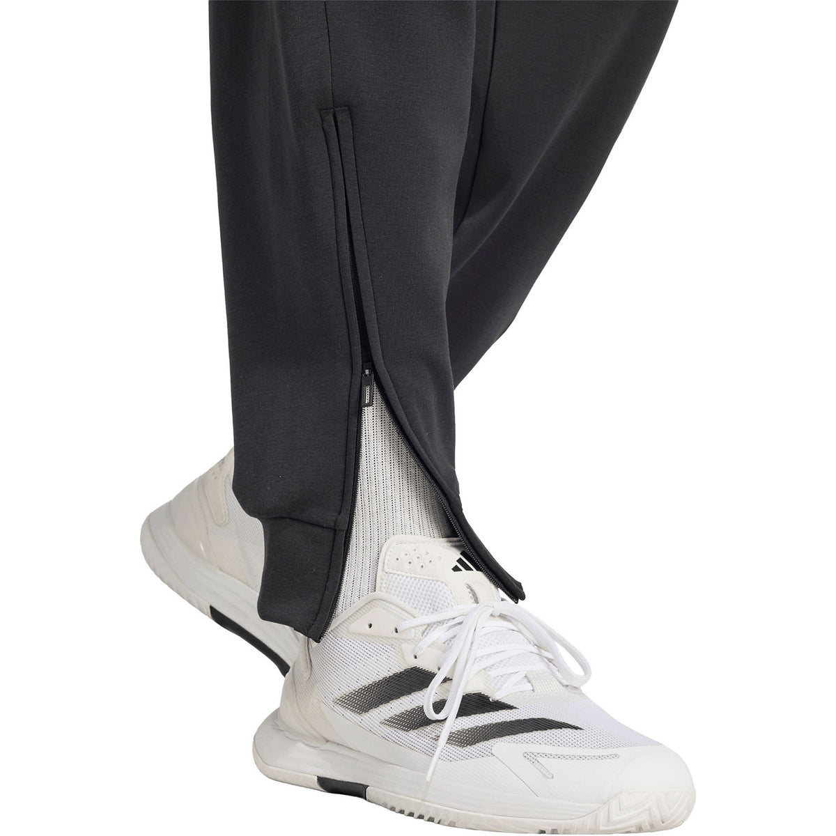 Detail van de rits bij de enkel van de zwarte Cover Up trainingsbroek