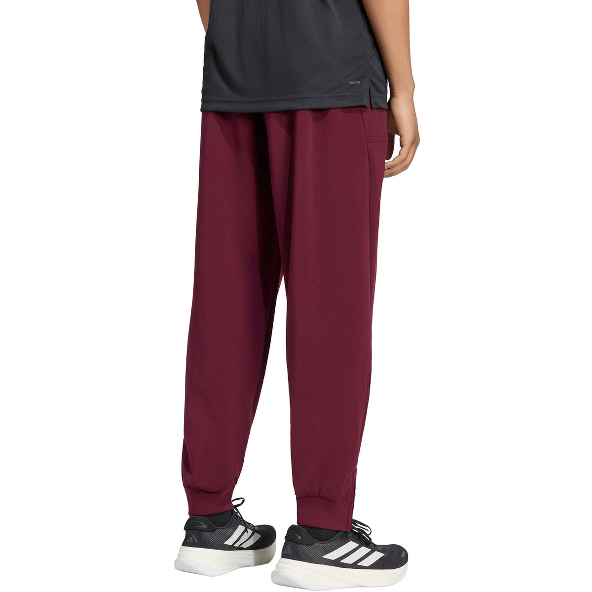 Zijaanzicht van de bordeauxrode Adidas Cover Up trainingsbroek op model