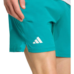 Detail van het witte adidas-logo op de pijp van de turquoise Ergo short