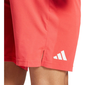 Detail van het adidas-logo op de pijp van de koraalrode Ergo short