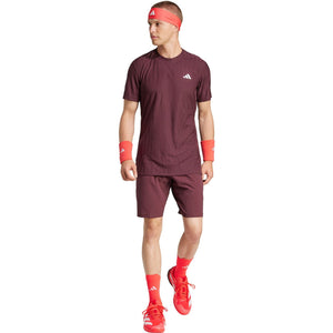Model draagt de bordeauxrode Adidas Ergo short met bijpassend shirt