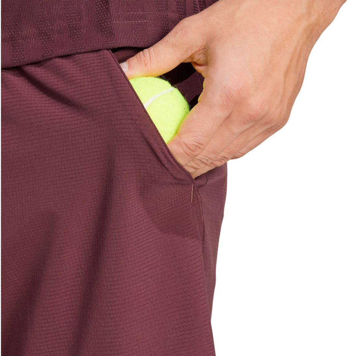 Model stopt een bal in de zak van de bordeauxrode Adidas Ergo short
