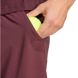Model stopt een bal in de zak van de bordeauxrode Adidas Ergo short