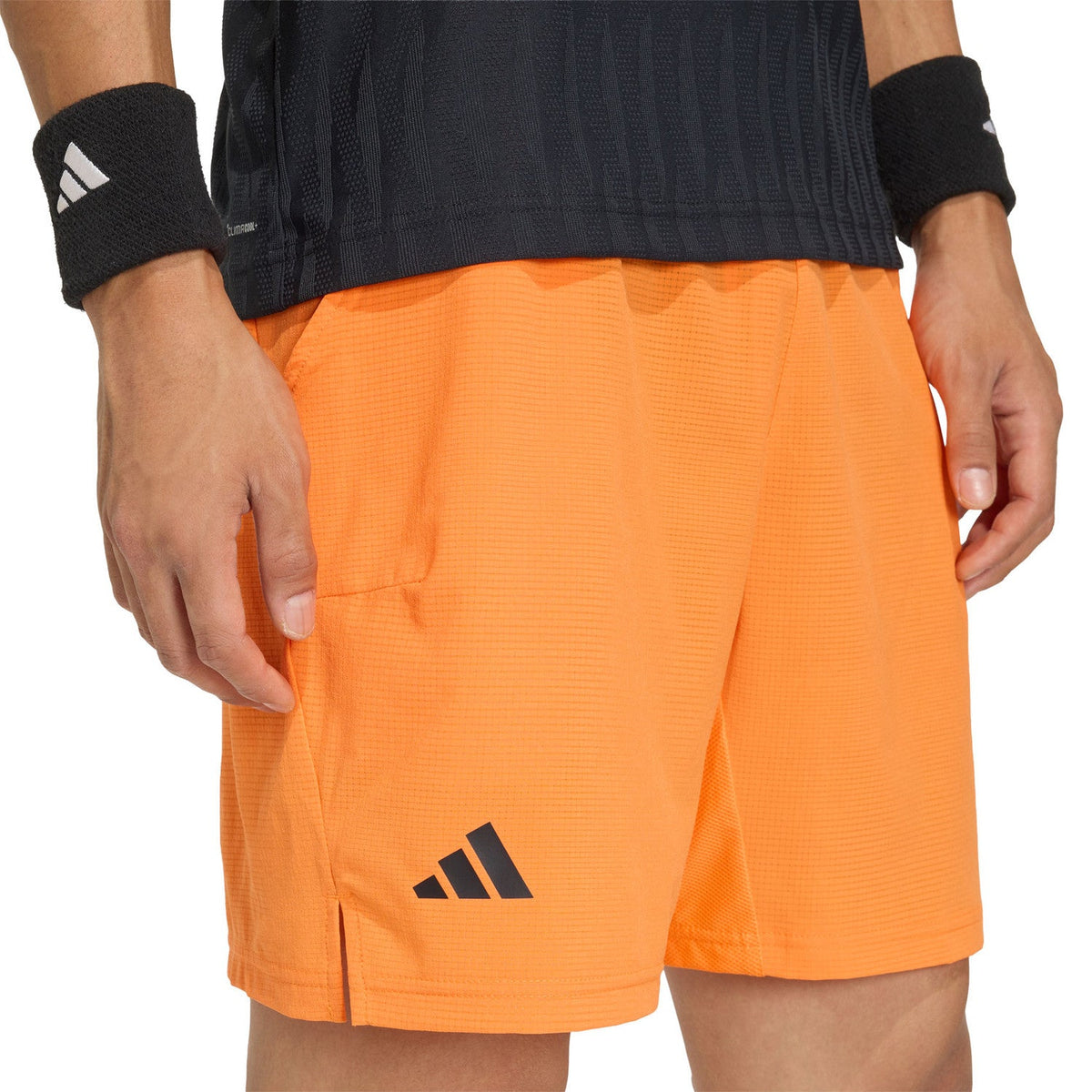 Detail van het adidas-logo op de pijp van de oranje Ergo short