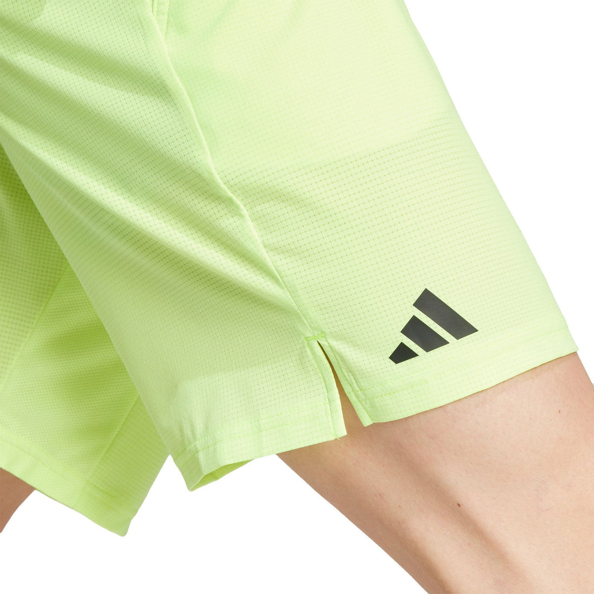 Detail van het adidas-logo op de pijp van de limoengroene Ergo short