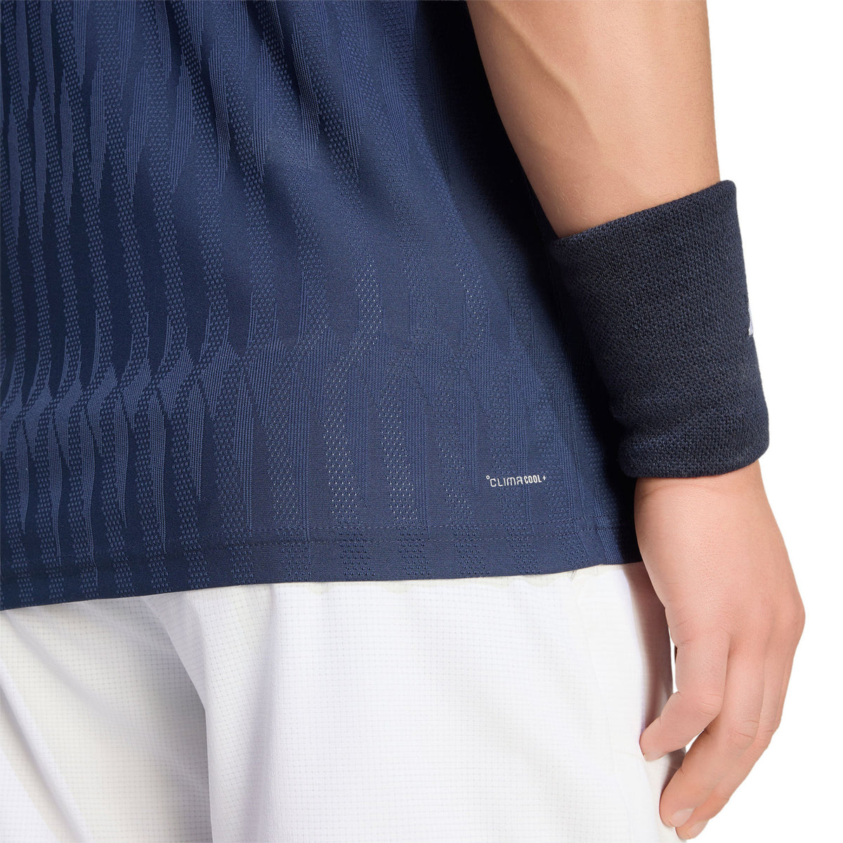 Detail van de mouw en zoom van de donkerblauwe Adidas Freelift polo