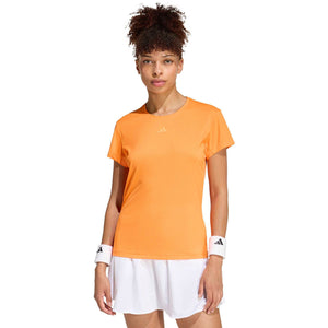 Model draagt het oranje Freelift T-shirt met witte short, vooraanzicht