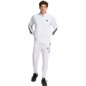 Model in volledige witte outfit met het Adidas 3-Stripes jack en bijpassende broek