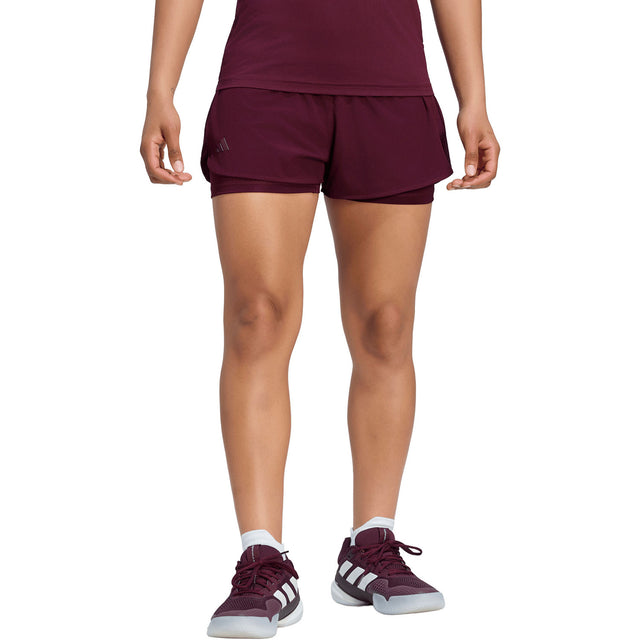 Model draagt de bordeauxrode Adidas Match short voor dames, vooraanzicht