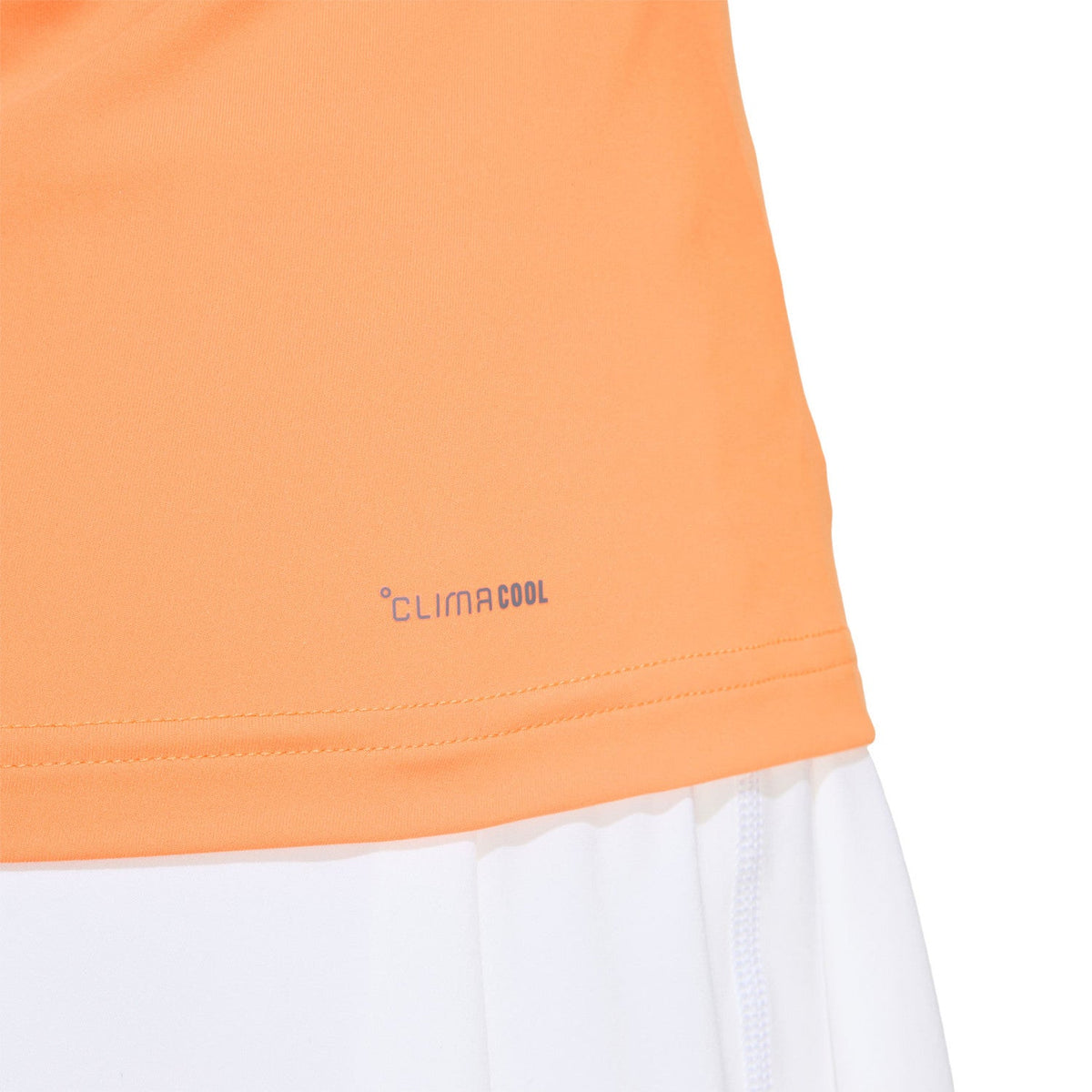 Detail van de zoom van de oranje Adidas Match tanktop boven de witte short