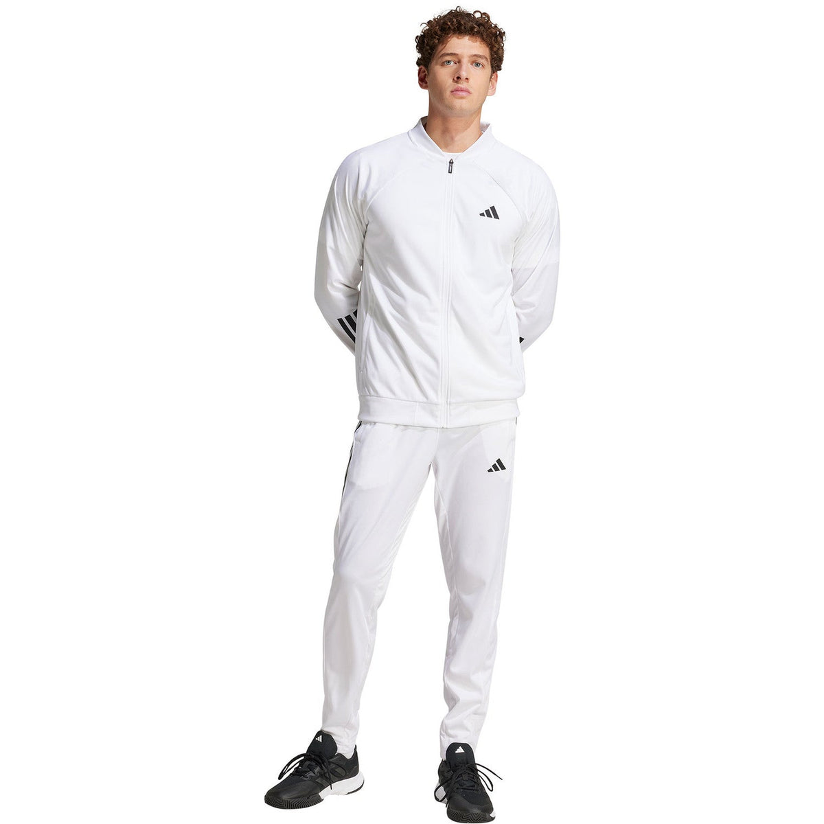 Model in volledige witte outfit met de Adidas 3-Stripes broek en bijpassend jack