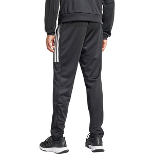 Model draagt de zwarte Adidas 3-Stripes broek met zwarte sportschoenen, vooraanzicht