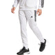 Model draagt de witte Adidas 3-Stripes gebreide trainingsbroek met bijpassend jack