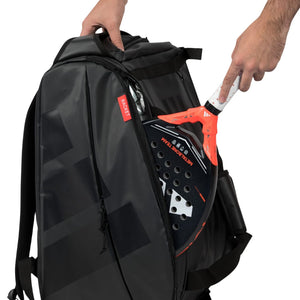Hand haalt een padelracket uit het racketvak van de zwart-rode Adidas Multigame 2026.