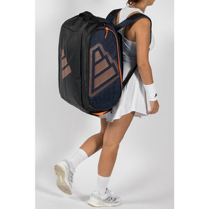 Speelster draagt de donkerblauwe Adidas Protour 2026 racketbag als rugzak.