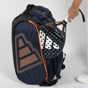 Hand haalt een racket uit het vak van de marineblauwe Adidas Protour 2026 racketbag.