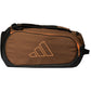 Zijaanzicht van de bruine Adidas Racket Bag Tour 2026 met oranje logo en rits.