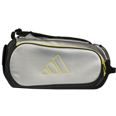 Zijaanzicht van de zilvergrijze Adidas Tour 2026 racketbag met geel logo en zwarte band.