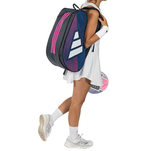 Speelster draagt de blauw-roze Adidas Control 2026 racketbag op haar rug.